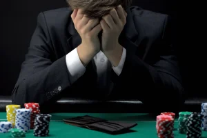Lawmakers introduce bipartisan POINTS Act targeting gambling addiction treatment funding. Young devastated businessman losing poker game at casino, gambling addiction